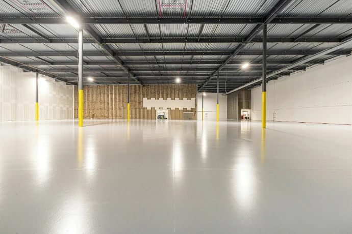 Spacious empty warehouse interior with polished concrete floor.